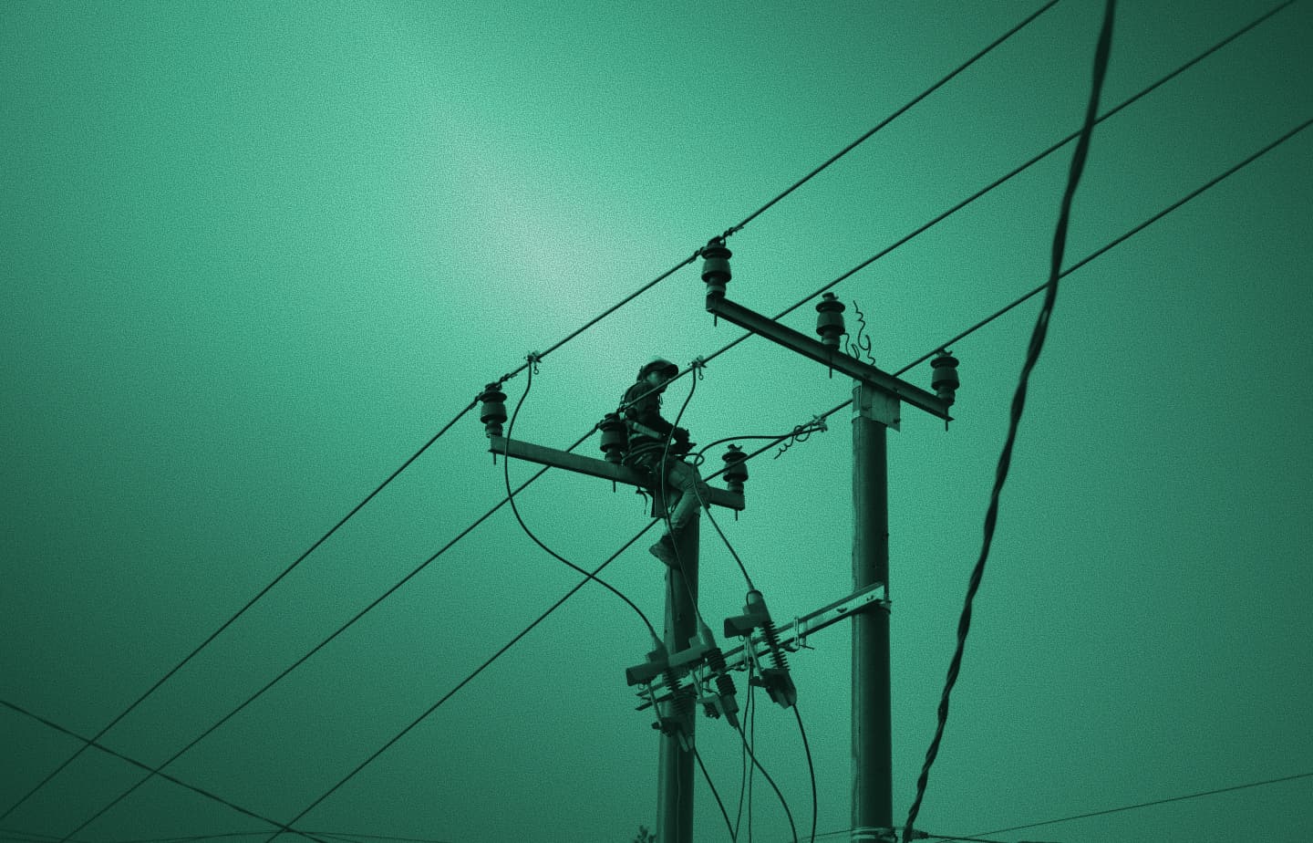 Utility worker on a power pole among electrical lines, silhouette with green tint