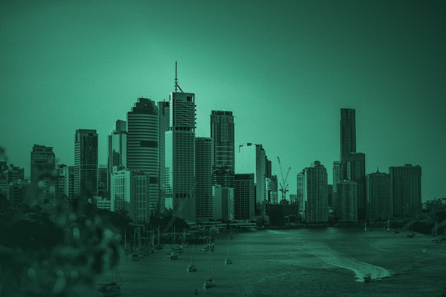 Brisbane skyline across the river with skyscrapers and boats, green monochrome photo