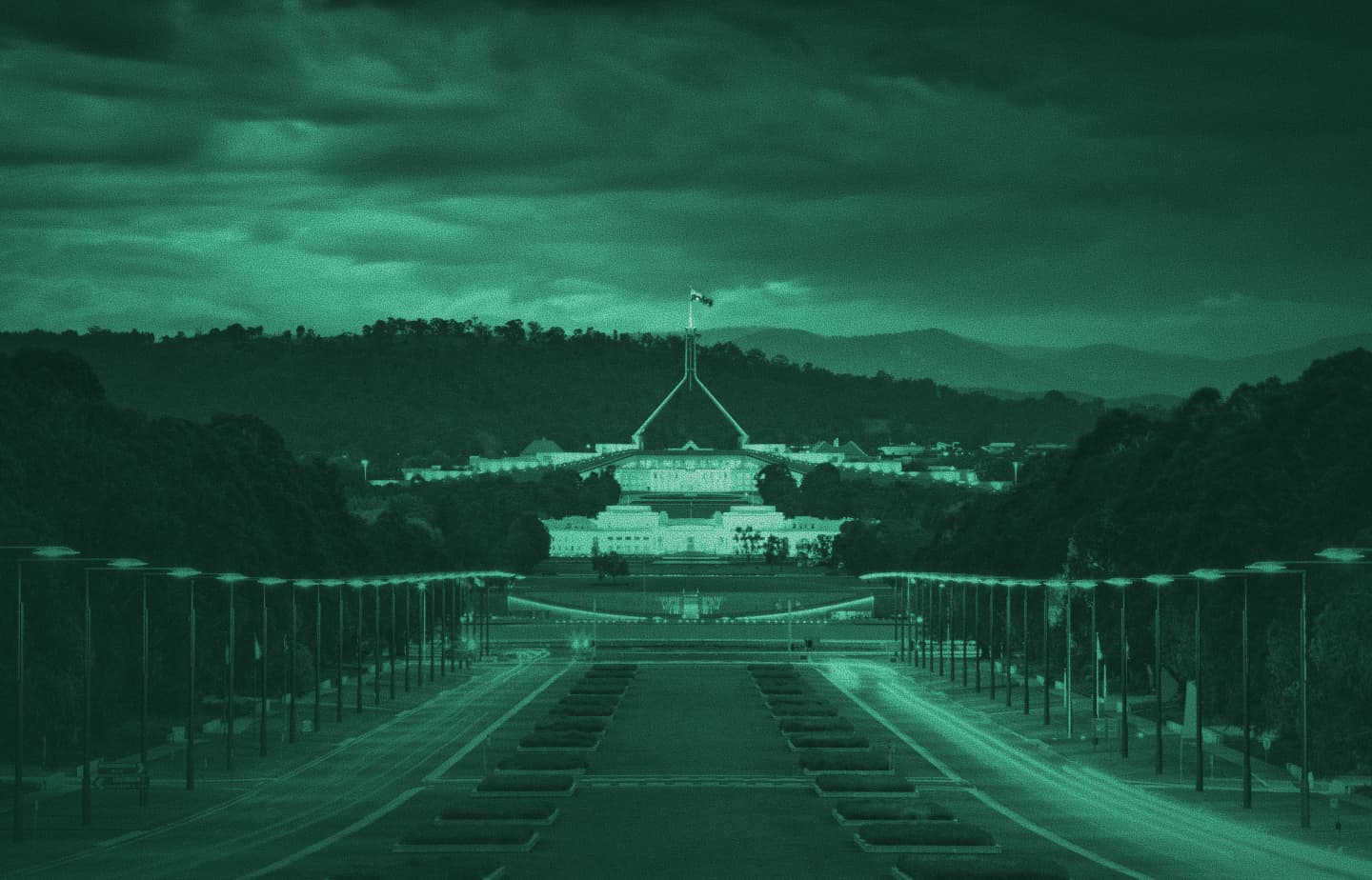 Night view down Anzac Parade toward Australian Parliament House in Canberra, green tint